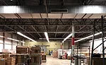 Before: The existing factory space had many surfaces that could collect dust. A ceiling was required to meet FDA and health department regulations for food processing facilities.