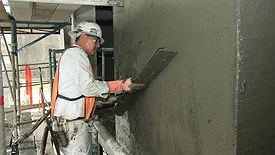 A man applying stucco to a wall