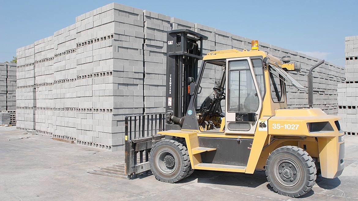 A forklift in front of cement blocks