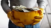 Person Holding Hard Hat With Money Getty Images Person Holding Hard Hat With Money Getty Images