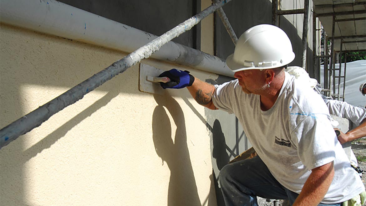 A worker finishing a Stucco Wall