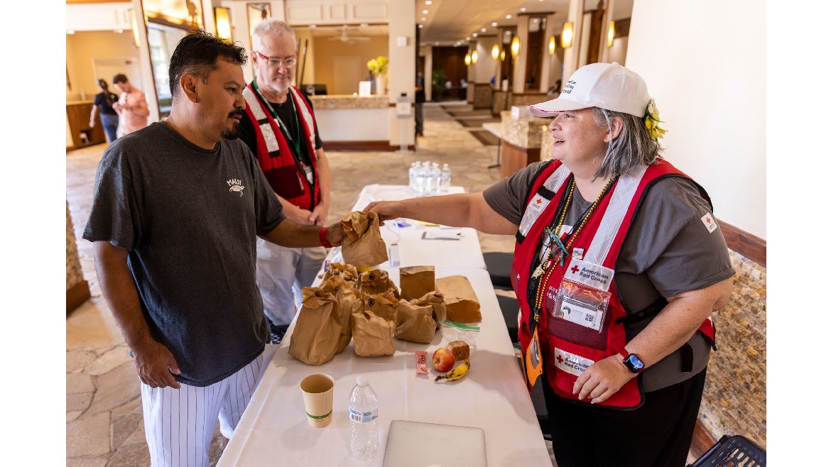 Red Cross Worker Handing Food To Resident