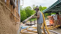 A man applies a hemp-based blown insulation