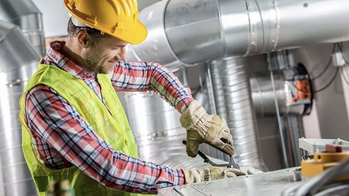 A man works on a ventilation pipe