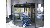Person Riding Wheelchair Through Revolving Door