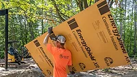 Continuous Insulation for New Construction A man holding an insulation panel