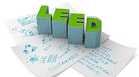 A clipart image of the word LEED in block letters over blueprints and diagrams