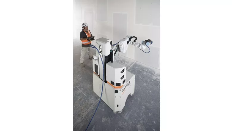 A construction worker with a drywall Robot