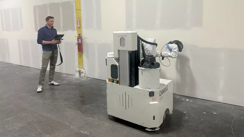 Kevin Albert demonstrating a drywall robot at work