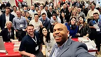 A selfie image of USG employees at a corporate office