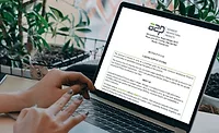 someone types at a computer with an image of a blog template