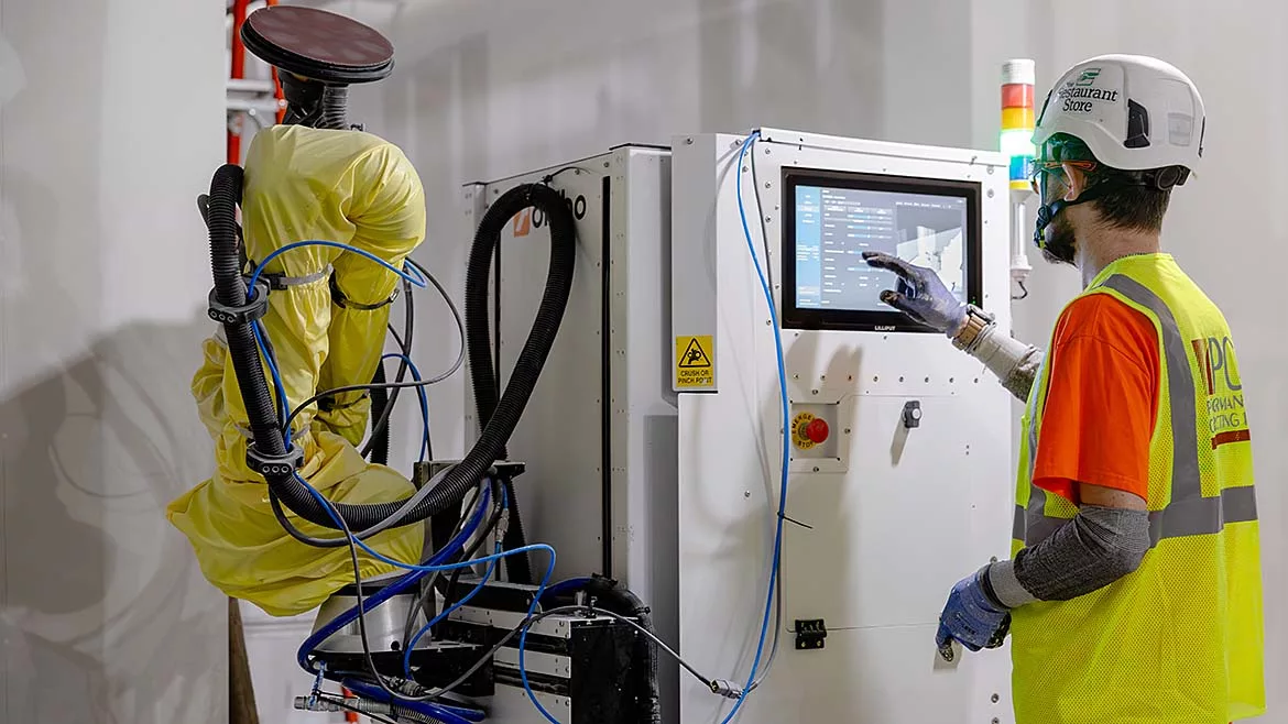 A man operating a drywall robot
