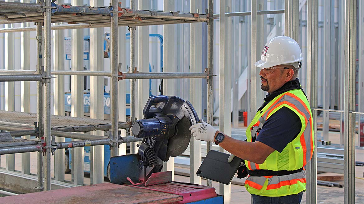 A construction worker using a saw