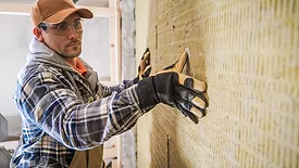 A man installing an insulation panel