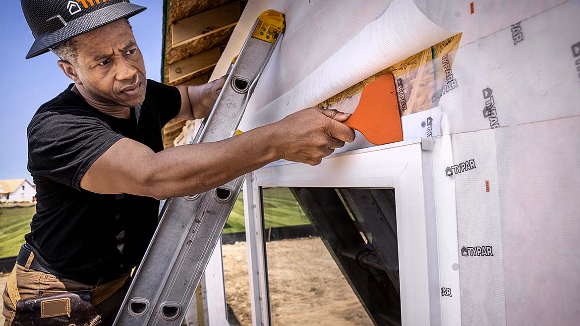A man applying transparent acrylic flashing