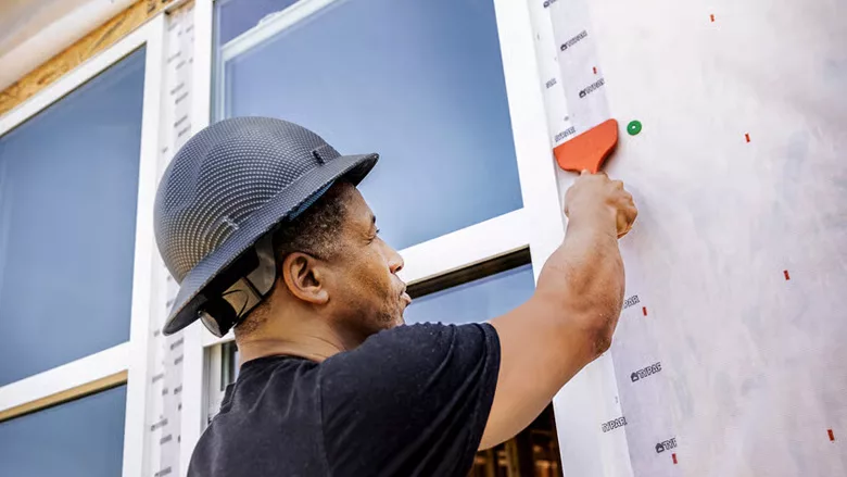 A man applying flashings to a house