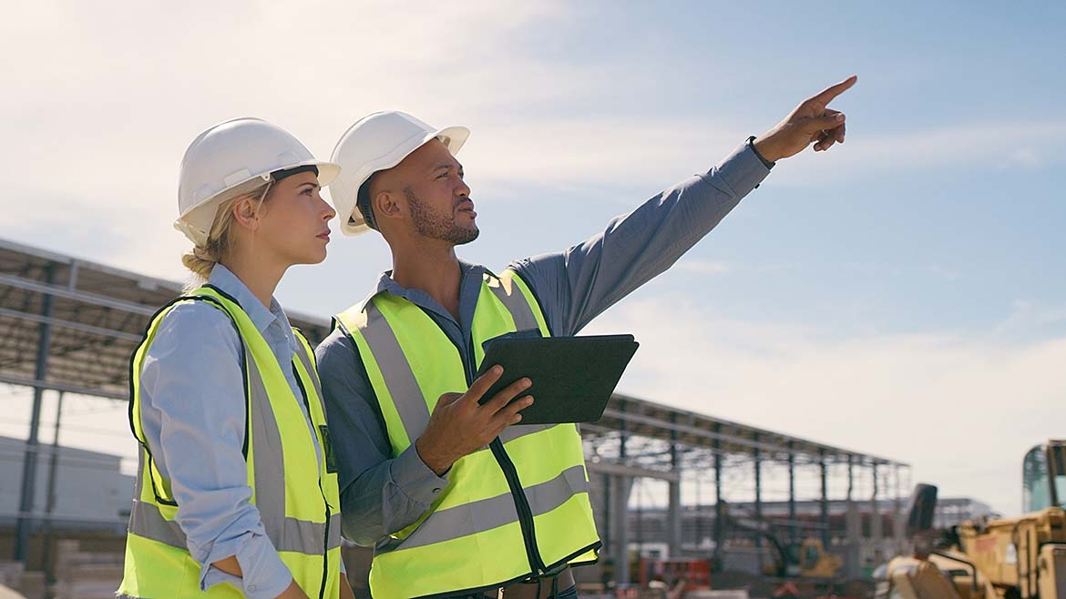 2 construction workers looking to the future. One of them sees a bird.