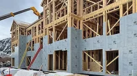 INsulation being added to the wooden frame of a building