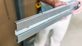 A worker holding the StepStuds product before installation