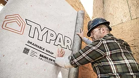  Man installing Typar drainable wrap on a building wall. 