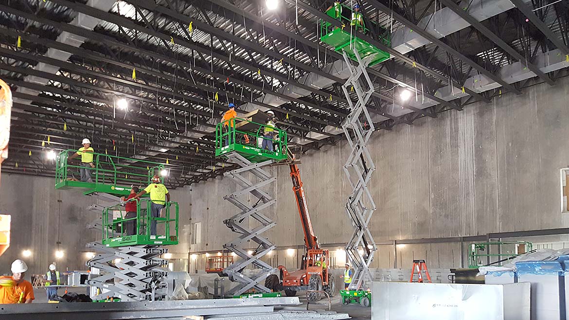 Several workers on aerial lift platforms