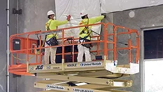 2 builders in PPE using an aerial lift