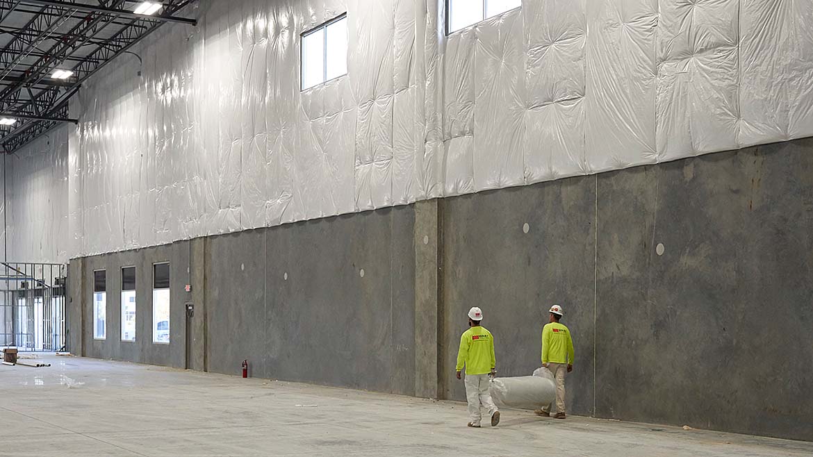 2 builders in PPE during a large-scale installation project