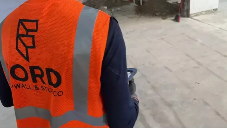 A Ford Drywall employee working the Dusty product